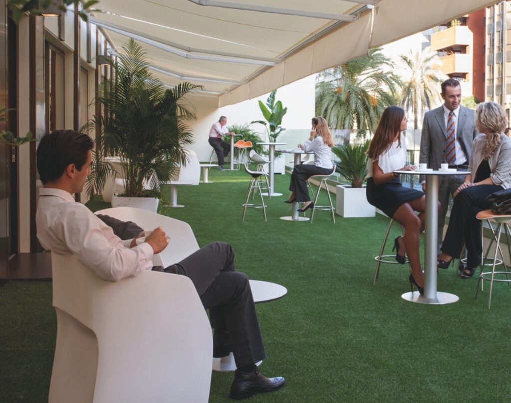 Profesionales en la terraza del centro de negocios TRBC, disfrutando de espacios de trabajo flexibles en Sevilla.